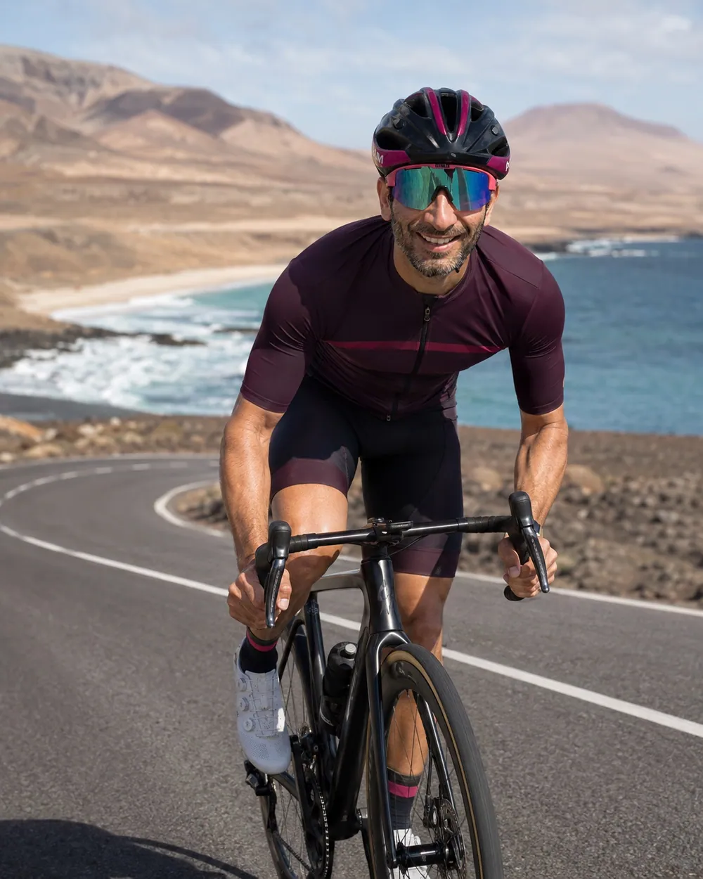 Navin cycling towards the camera on a coastal road.